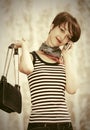 Happy young fashion woman with handbag calling on cell phone Royalty Free Stock Photo