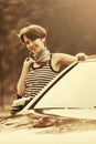 Happy young fashion woman with handbag leaning on her car Royalty Free Stock Photo