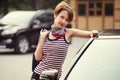 Happy young fashion woman with handbag next to her car Royalty Free Stock Photo