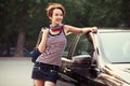 Happy young fashion woman with handbag next to her car Royalty Free Stock Photo