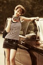 Happy young fashion woman with handbag next to her car Royalty Free Stock Photo