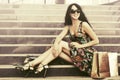 Happy young fashion woman with shopping bags on mall steps Royalty Free Stock Photo