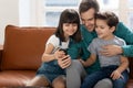 Happy dad and little kids have fun using cellphone together Royalty Free Stock Photo