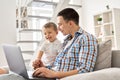 Happy young father and cute toddler kid son using laptop computer at home. Royalty Free Stock Photo