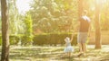 Happy young father holds his little girl by the hand walking in summer park. family, parenthood, fatherhood, adoption and people Royalty Free Stock Photo