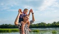 Happy young father holds his son piggyback ride on his shoulders Royalty Free Stock Photo