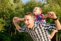 Happy young father holds his son piggyback ride on his shoulders Royalty Free Stock Photo