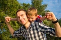 Happy young father holds his son piggyback ride on his shoulders Royalty Free Stock Photo