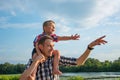 Happy young father holds his son piggyback ride on his shoulders Royalty Free Stock Photo