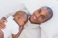 Happy young father napping with baby son on couch Royalty Free Stock Photo