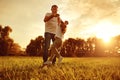 Happy young father plauing with child outside in park.