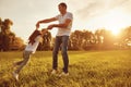 Happy young father plauing with child outside in park.