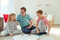 Happy young father plays with his two cheerful siblings children Board Game with colorful dices Royalty Free Stock Photo