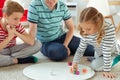 Happy young father plays with his two cheerful siblings children Board Game with colorful dices Royalty Free Stock Photo