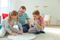 Happy young father plays with his two cheerful siblings children Board Game with colorful dices Royalty Free Stock Photo