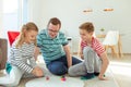 Happy young father plays with his two cheerful siblings children Board Game with colorful dices Royalty Free Stock Photo