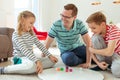 Happy young father plays with his two cheerful siblings children Board Game with colorful dices Royalty Free Stock Photo