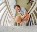 Happy young father putting his smiling baby in a white crib next to a window Royalty Free Stock Photo