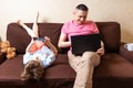 Happy young father sit on computer using laptop with son having a work video call. Smiling dad and little boy child legs Royalty Free Stock Photo