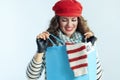 Happy young female with blue shopping bag checking purchases Royalty Free Stock Photo