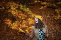 Happy young female in brown coat and yellow hat Royalty Free Stock Photo