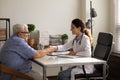 Smiling female doctor handshake mature patient in hospital