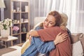 Glad girl hugging granny in room