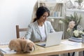 Happy young female entrepreneur enjoying workday with funny fluffy rabbit. Royalty Free Stock Photo