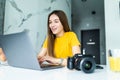 Happy young female executive looking at camera in creative office. Freelance photographer woman with camera at home office editing Royalty Free Stock Photo