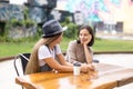 Happy young female friends sitting at table and drinking coffee Royalty Free Stock Photo