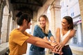 Happy young female friends stacking hands. Diverse group of people celebrating and having fun together. Royalty Free Stock Photo