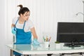 Young Female Janitor Cleaning Desk With Rag Royalty Free Stock Photo