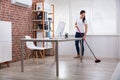 Young Janitor Cleaning Floor Royalty Free Stock Photo