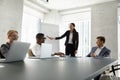 Happy young female manager presenting report to diverse business team Royalty Free Stock Photo