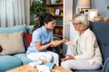 Happy young female nurse provide care medical service help support smiling old grandma at homecare medical visit, lady carer Royalty Free Stock Photo