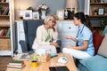 Happy young female nurse provide care medical service help support smiling old grandma at homecare medical visit, lady carer Royalty Free Stock Photo