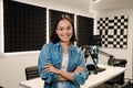 Happy young female radio host smiling while broadcasting in studio Royalty Free Stock Photo