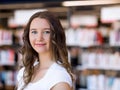 Happy female student holding books at the library Royalty Free Stock Photo