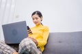 Happy young female surfing the internet shopping online at home after the government announced a ban on leaving the house.,