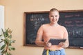 Happy young female teacher or student of highschool using tablet