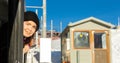 Happy female traveler poking head out of window of train driving among snowy areas