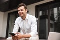 Happy young formal dressed man in earphones Royalty Free Stock Photo