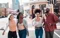 Happy, young and free trendy friends having fun on a day in the city, laughing while walking and talking together