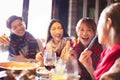 Happy young friends eating hot pot in restaurant at Royalty Free Stock Photo