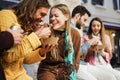 Happy young friends eating take away food outdoor in the city - Focus on center girl face