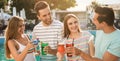 Happy young friends with fresh summer cocktails relaxing near swimming pool. Banner design Royalty Free Stock Photo