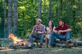 Happy young friends having picnic in the country. Company adult friends relaxing near campfire. Young couples having Royalty Free Stock Photo