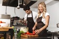 Happy young friends loving couple chefs on the kitchen cooking. Royalty Free Stock Photo