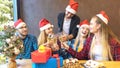 Happy young friends with santa hats celebrating Christmas with champagne and sweet food at brunch party Royalty Free Stock Photo