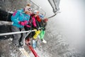 Happy friends skiers and snowboarders on ski lift for skiing in Royalty Free Stock Photo